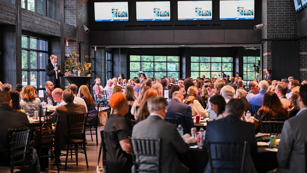 Annual Summit: Presentation viewers sitting at tables